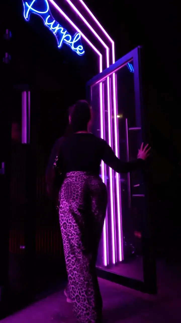 Une cliente entre dans l’univers Purple, entre néons violets et roses